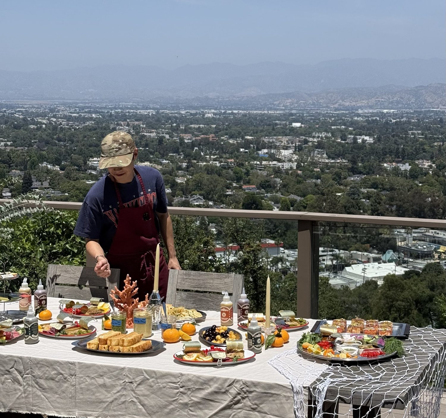 Alexander Yu's brother plating a spread on a hillside terrace overlooking Los Angeles